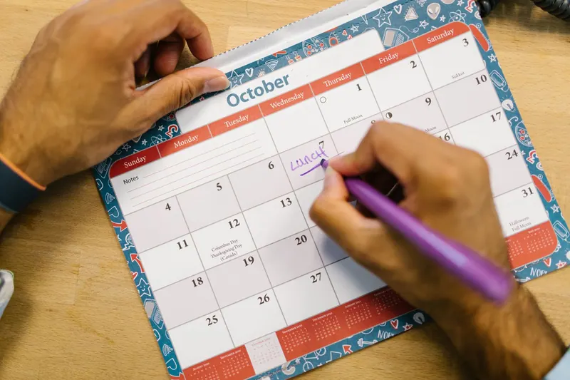 Kalender und Stift auf einem Holztisch